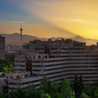 Dawn at the Ekbatan Complex in Tehran, Iran. The mountain creating the gigantic light shaft is mount Damavand.